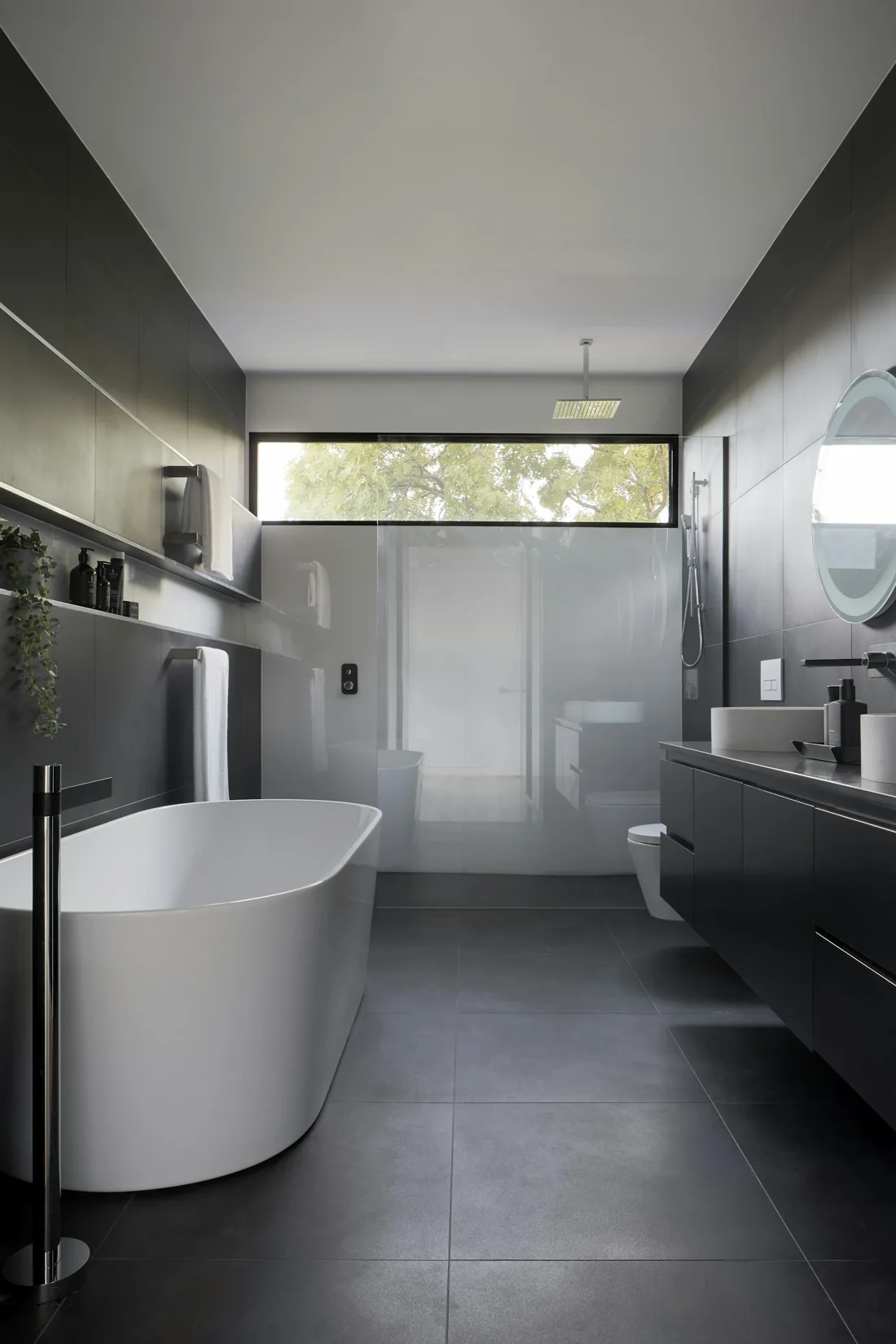 Freestanding bath, wood surfaces and a calm, light filled bathroom